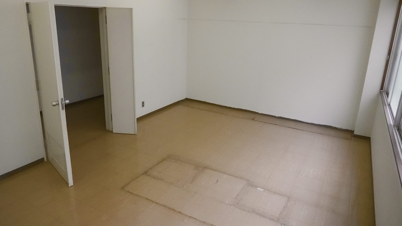 教材室の内観。白壁の小部屋で、出入口が写る