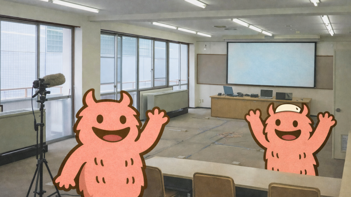 視聴覚室の室内写真に、手を振る「でっかいくん」と両手を上げた「でっかいくん」を2体配置したサムネイル画像